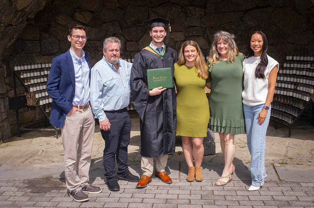 A student poses with friends and family after a graduation ceremony