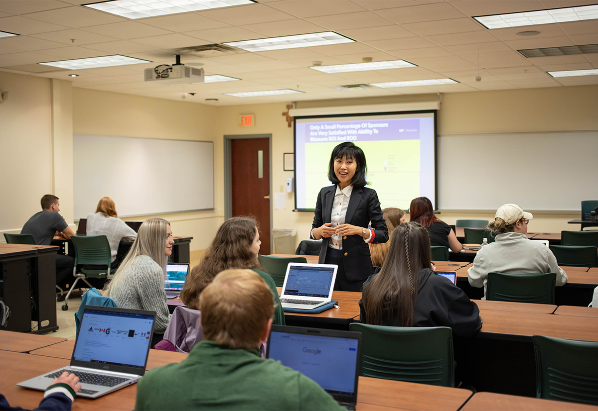 A female teacher walks around a classroom during an ROI lesson